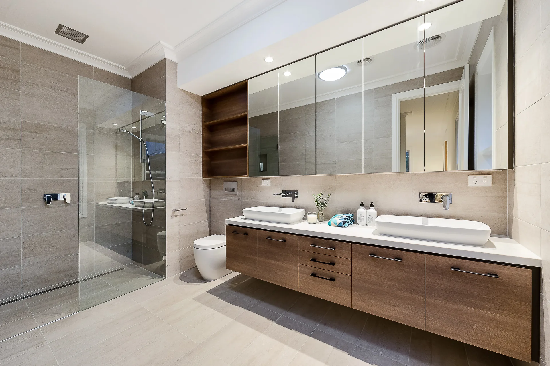Modern bathroom with a double vanity, a walk-in shower and stone tile