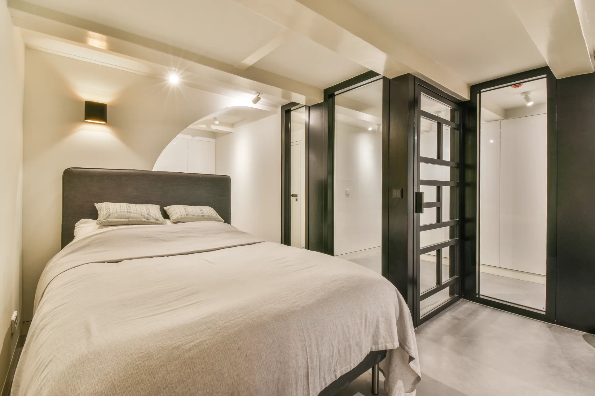 Quiet bedroom with linen bedding and black-framed closet doors