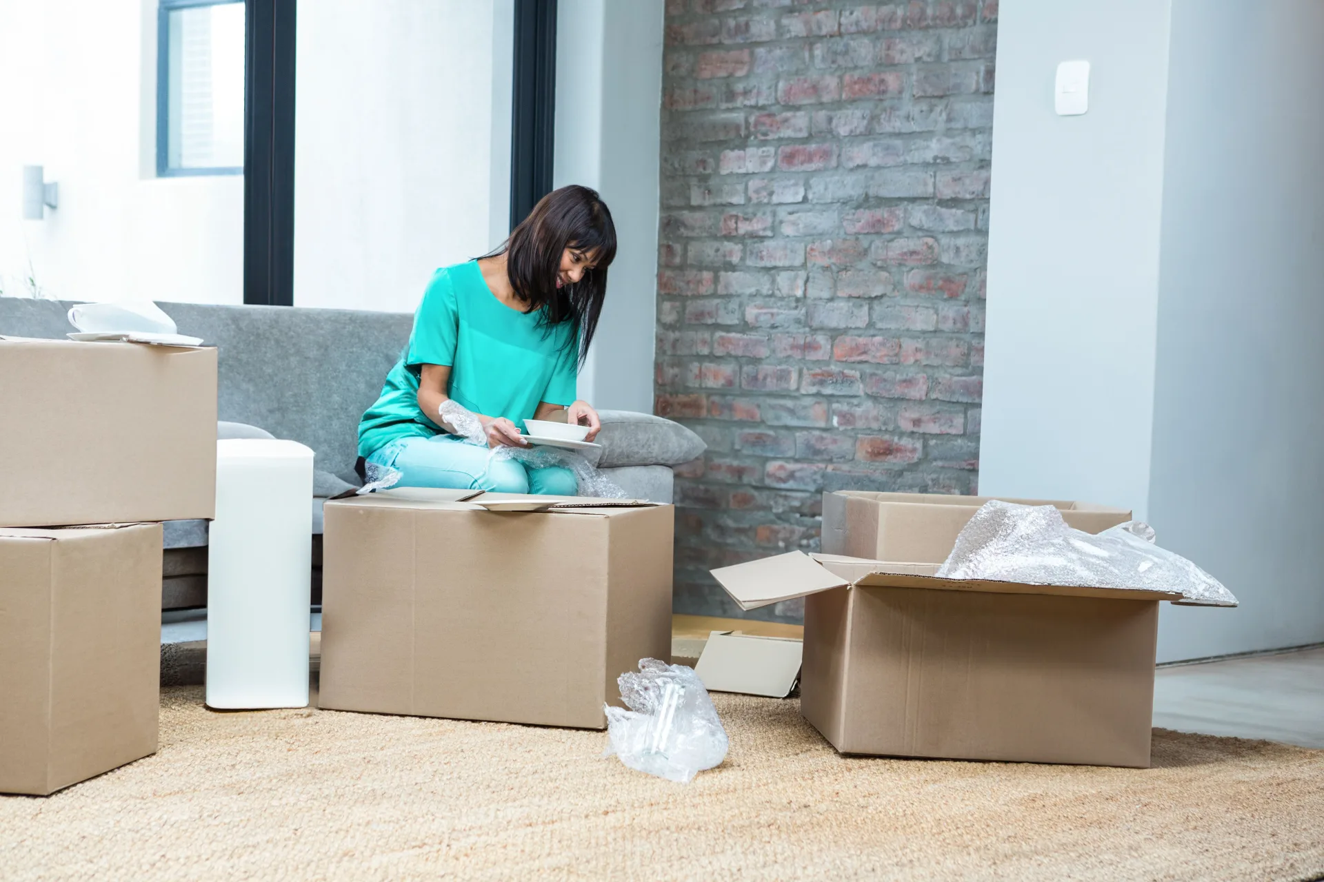 A woman unpacking plates from a box in a newly cleaned home