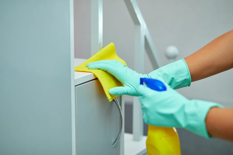 Two Olimpia cleaners detailing a marble bathroom and its glass shower